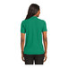 A woman wearing a kelly green Port Authority polo shirt.