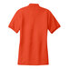 An orange Port Authority silk touch polo shirt with a white collar.