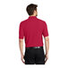 A man wearing a red Port Authority® silk touch polo shirt.