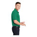 A man wearing a Kelly green Sport-Tek short sleeve polo.