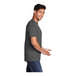 A man wearing a dark heather gray Port & Company T-shirt.