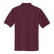 A close-up of a medium maroon Port Authority polo shirt.