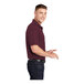 A man wearing a maroon Sport-Tek short sleeve polo shirt.