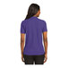 A woman wearing a purple Port Authority polo shirt.