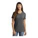 A woman wearing a dark heather grey Port & Company short sleeve t-shirt.