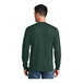 A man wearing a dark green Port & Company long sleeve T-shirt.