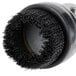 A close-up of a black circular brush with round bristles.