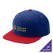 A close-up of a blue and red Sport-Tek baseball cap with a flat bill and snapback closure.