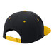 A black snapback hat with a yellow brim and yellow dots on the front panel.