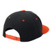 A black 6-panel hat with orange accents including a brim and dots.