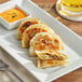 A plate of Jaju Loaded Baked Potato Pierogies with a fork.