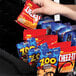 A hand using the Selectivend snack vending machine to buy a bag of chips.