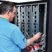 A man in a blue shirt opening a vending machine.