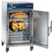 An Alto-Shaam stackable cook and hold oven with chicken and other food inside.