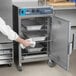 A chef putting food into an Alto-Shaam cook and hold oven.