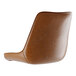 A brown vinyl tufted cushion on a curved back chair.