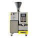 A yellow and black Astra Super Mega I automatic coffee machine with a cup on it.