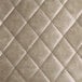 A close up of a tufted leather cushion in a quilted pattern.