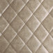 A close up of a gray vinyl tufted leather surface on a black barstool.