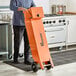 A man in a chef's uniform holding an orange Fryclone box.
