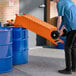 A man pushing a Fryclone fryer oil shuttle with an orange wheel.