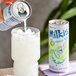A hand pouring Milkis melon milk soda into a glass.