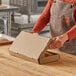 A person in an apron opening a Choice Kraft corrugated flatbread box.