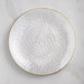 A Visions clear plastic coupe plate with a gold rim.