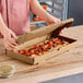 A person opening a Choice Kraft flatbread box to reveal a pizza.