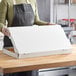 A woman holding a white Choice flatbread box.