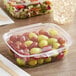 A clear Good Natured GoodGuard plastic container filled with grapes and other fruit.