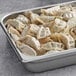 A metal pan filled with Chef One Edamame Dumplings on a counter.