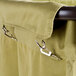 A close up of a green canvas bag hanging on a metal hook.