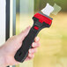 A hand holding a black and red Allway Tools Long Handle Utility Scraper.