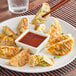 A plate of Chef One vegetable dumplings with dipping sauce.