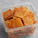 A plastic container of Issa's Spicy Harissa Pita Chips on a table.