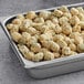 A pan of Stilwell Heavily Breaded IQF Okra pieces on a table.