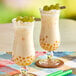 Two glasses of Fanale white grape drink with grapes in it.