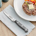A steak on a plate with a Choice Classic steak knife.