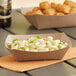 A Southern Champion paper food tray holding macaroni and cheese on a table.