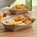 A tray of fried chicken and french fries on a table in a farm-to-table restaurant.