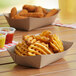 A Southern Champion paper food tray of waffle fries with dipping sauce.