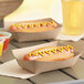 Two hot dogs in Southern Champion paper food trays with mustard.