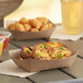 A Southern Champion paper food tray with a baked potato, tater tots, and a drink.