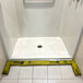 A shower with a Quick Dam yellow absorbent water barrier on the floor.