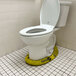A Quick Dam yellow absorbent water dam around a toilet in a bathroom.