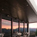 A Boltic black electric infrared heater on a table on a commercial patio.