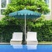 Two white cushioned chairs under a blue 7.5ft patio umbrella with a scalloped edge.