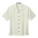 A Port Authority ivory camp shirt for men with a buttoned collar and two buttons.