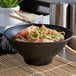 An Elite Global Solutions black melamine bowl with noodles, shrimp, and vegetables.